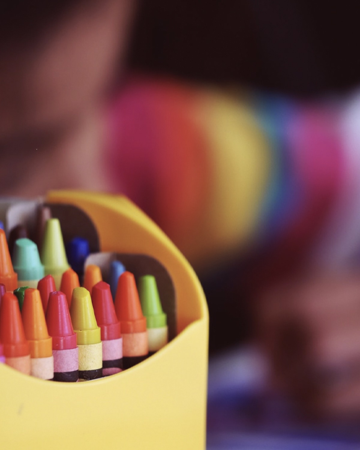 A box of colorful crayons at the learning table
