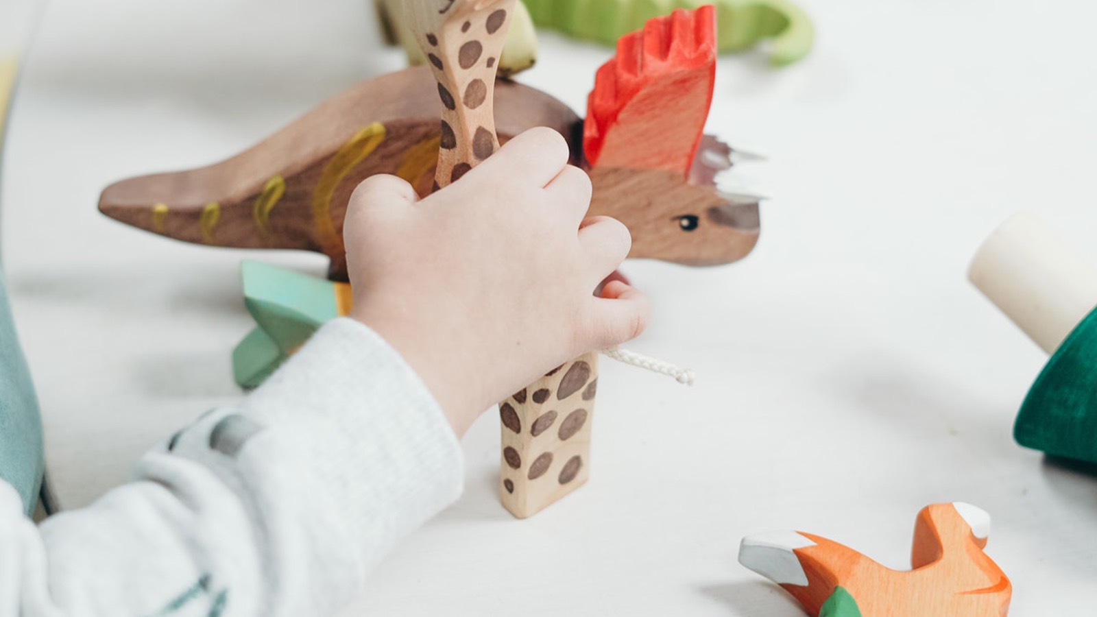 A child playing with wooden animal toys